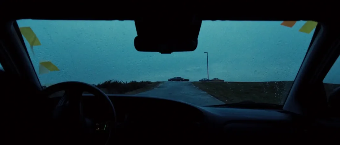 The road ahead seen through a freshly installed windshield, retention tape still on the pillars.